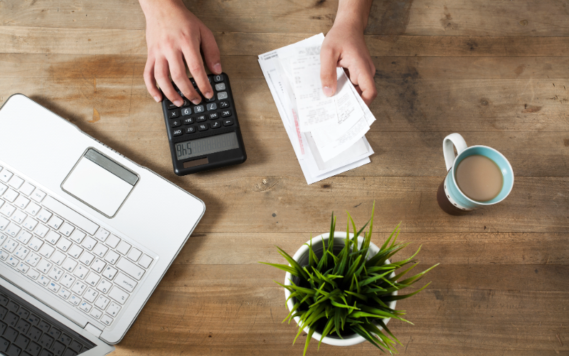 Hand of person using calculator and calendar