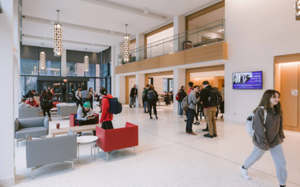 Students walking and visiting in building lobby