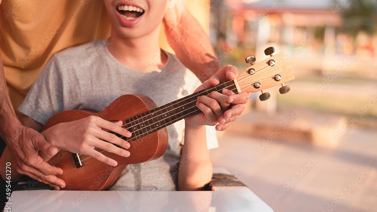 Young boy in ukulele lessson-Adobe stock photo